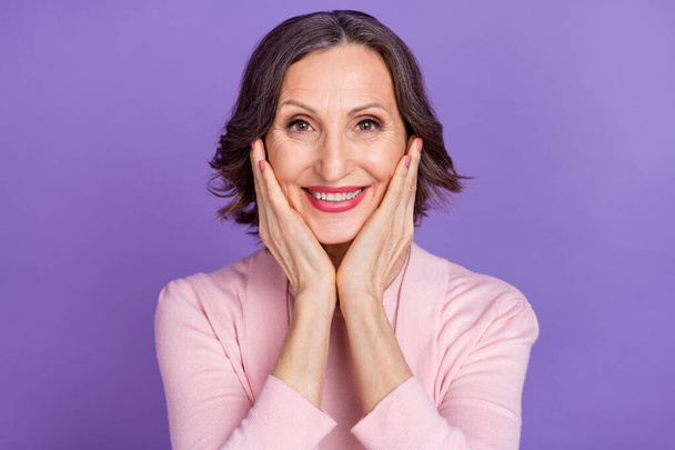 Portrait of satisfied glad aged person hands cheeks toothy beaming smile isolated on violet color background - Zdjęcie, obraz