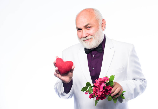 anniversary and valentines day. donor transplant. love and romance. Health care treatment. problems with heart. bearded businessman. heart failure. mature man hold flowers and heart. fathers day - Fotografie, Obrázek