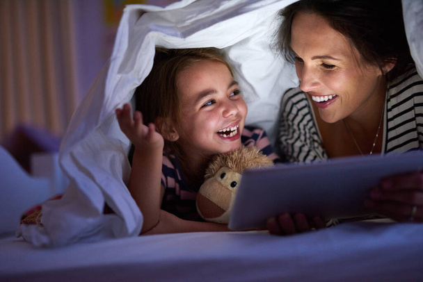 Can we read another one, Mom. Cropped shot of an attractive young woman reading her daughter a bedtime story. - 写真・画像