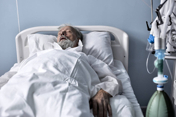 Καυκάσιος ηλικιωμένος ασθενής ξαπλωμένος στο κρεβάτι στην πτέρυγα του νοσοκομείου. Μοναχικός γέρος. - Φωτογραφία, εικόνα