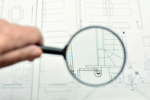 Concept of looking at a blueprint with a magnifying glass, architectural project - Photo, Image