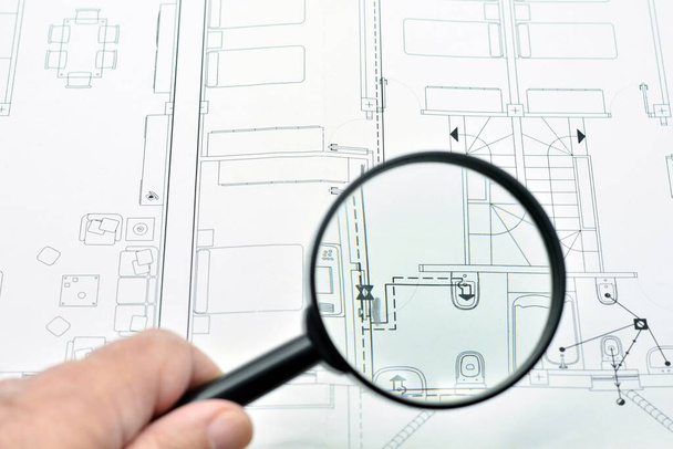 Concept of looking at a blueprint with a magnifying glass, architectural project - Foto, imagen