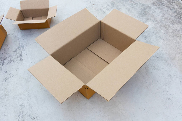 Ouvrir boîte en carton brun vide sur le sol en béton - Photo, image