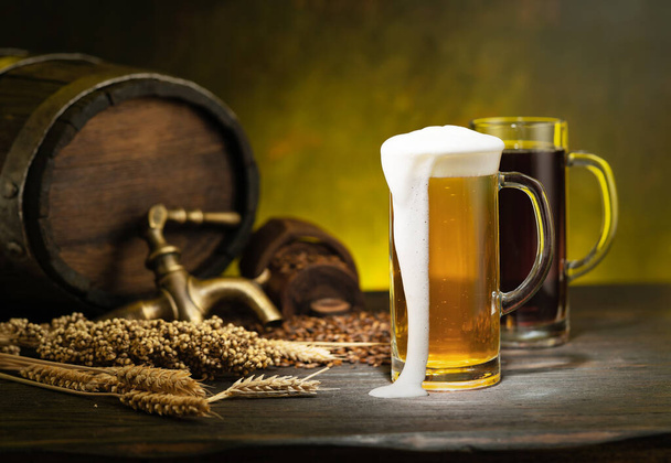 Beer barrel with beer glasses on a wooden table. Dark amber background. - Фото, изображение