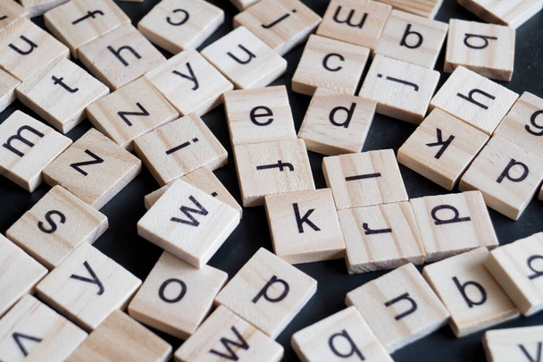 Alphabet letters on wooden scrabble pieces, close up - Photo, Image
