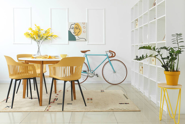Interieur des modernen Zimmers mit Tisch, Stühlen und Fahrrad - Foto, Bild