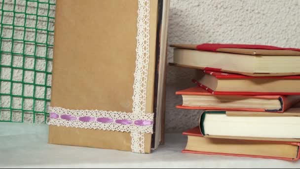 hromada knih ležících jeden na druhém v knihovně - Záběry, video