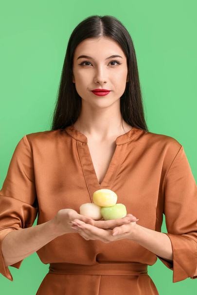 Beautiful young woman with tasty Japanese mochi on color background - Foto, immagini