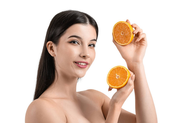 Pretty young woman with orange on white background - Photo, Image