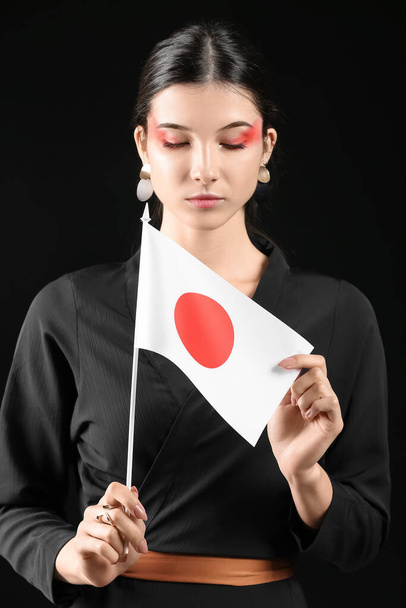 日本の国旗を背景に美しい若い女性 - 写真・画像
