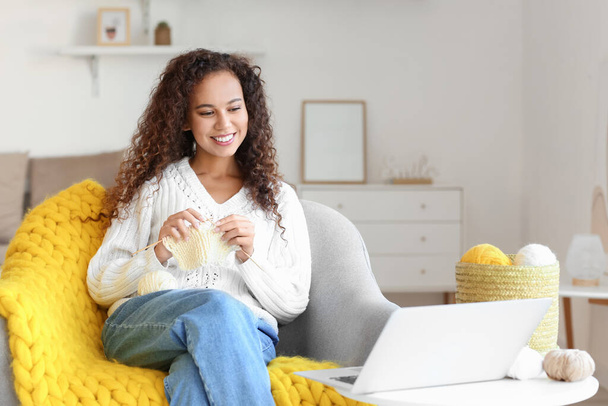 若いアフリカ系アメリカ人の女性は自宅でオンライン編み物教室を取る - 写真・画像