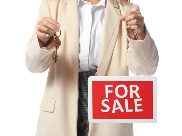 Афроамериканський агент з нерухомості з знаком "За продаж" і ключем на білому тлі - Фото, зображення