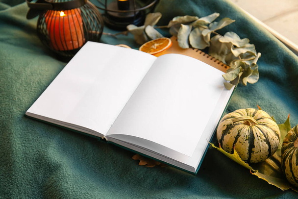 Λευκό βιβλίο και φθινοπωρινή διακόσμηση σε καρό, closeup - Φωτογραφία, εικόνα
