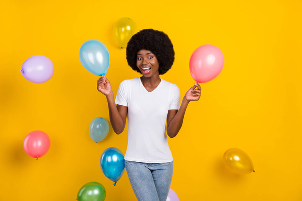 Photo of excited happy dark skin young lady fall balloons party good mood isolated on yellow color background - Fotó, kép