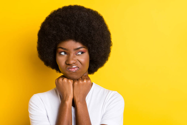 Photo of unhappy sad dark skin young woman look empty space bad mood isolated on yellow color background - 写真・画像