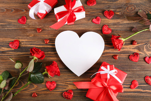 Prázdná karta ve tvaru srdce, růže a dárky na Valentýna na dřevěném pozadí - Fotografie, Obrázek