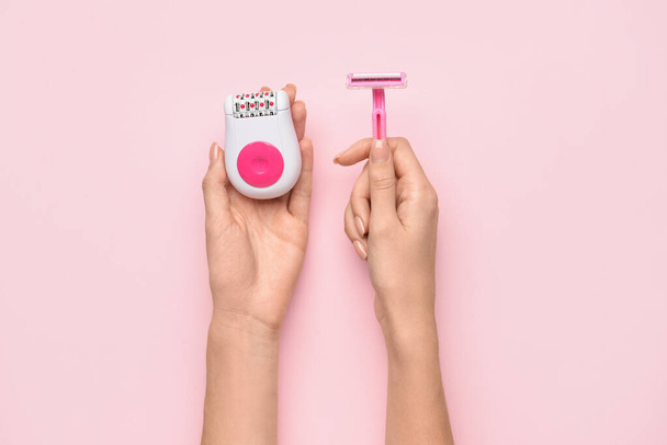 Female hands with modern epilator and razor on pink background - Foto, Imagem