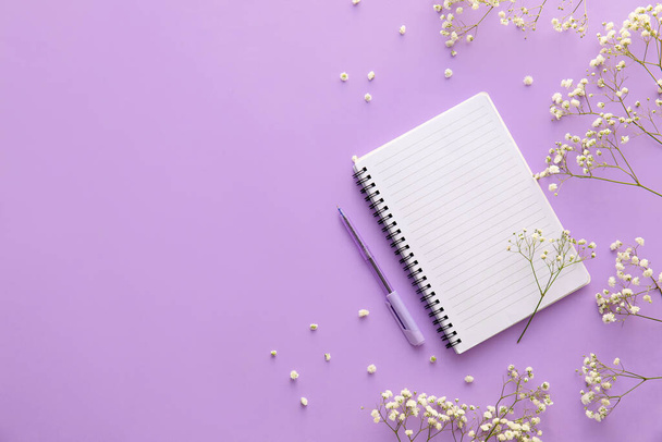 Caderno em branco, caneta e flores de gypsophila sobre fundo lilás - Foto, Imagem