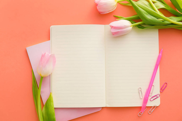 Composition with notebooks, tulips and pen on color background - Foto, afbeelding