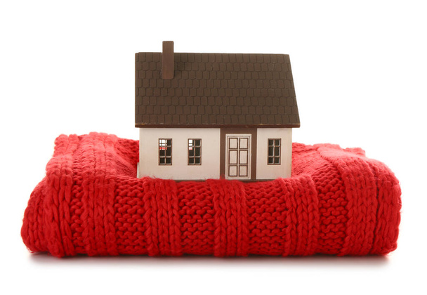 Modelka domu s červenou šálou na bílém pozadí. Koncept vytápění - Fotografie, Obrázek