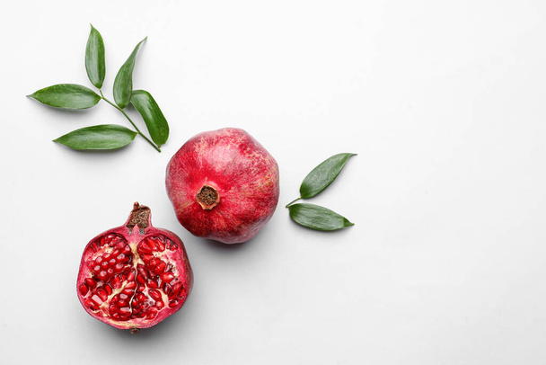Ripe delicious pomegranate on light background - Foto, afbeelding