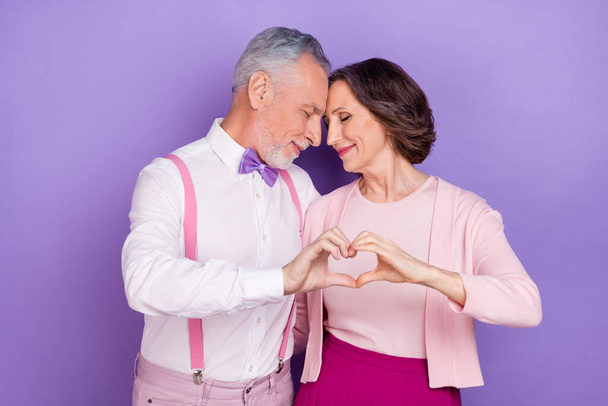 Photo of two peaceful soulmates closed eyes touch head hands show heart symbol isolated on violet color background - Photo, Image
