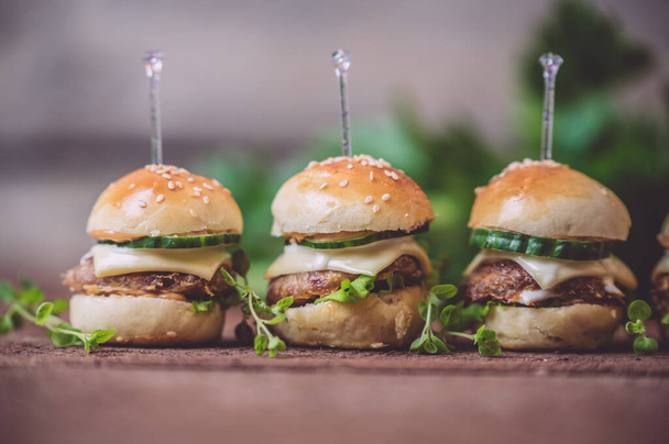 Close up of mini beef burgers isolated on wood background - Foto, afbeelding