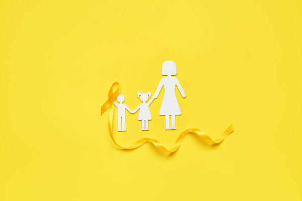 Sarı arka planda çocuklu annenin altın farkındalık kurdelesi ve silueti. Uluslararası Çocukluk Kanser Günü - Fotoğraf, Görsel