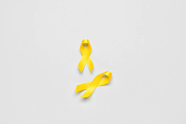 Golden awareness ribbons on light background. International Childhood Cancer Day - Photo, Image