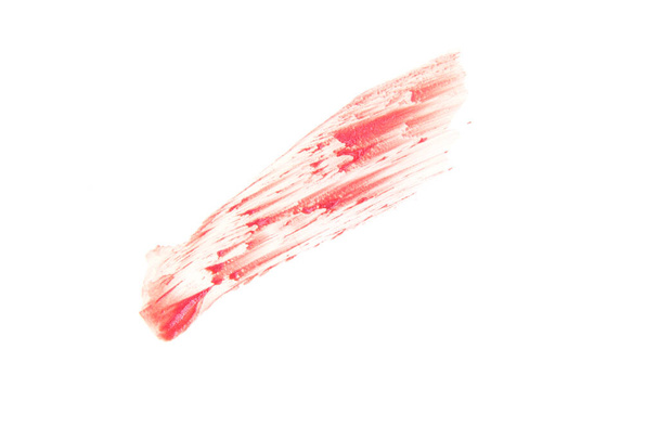 Close-up smear of lip gloss texture. The coral color is highlighted on an isolated white background. An element for the design of cosmetic cosmetics. - Photo, image