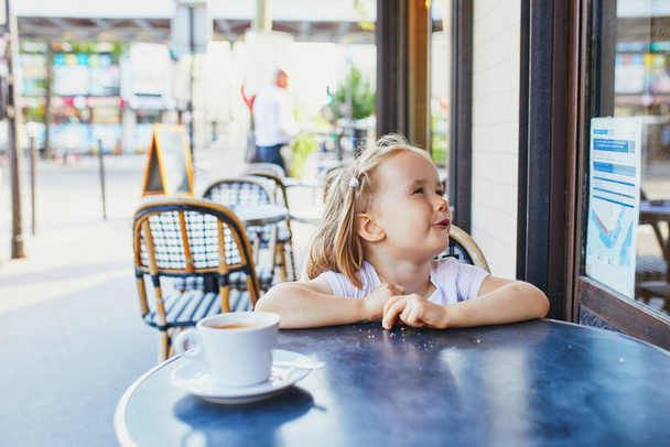 Adorable three year old girl in Parisian cafe or restaurant. Going out with kids concept - Foto, afbeelding