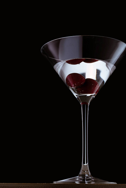 Siyah yansıtıcı arka planda bir bardak kırmızı martini. - Fotoğraf, Görsel