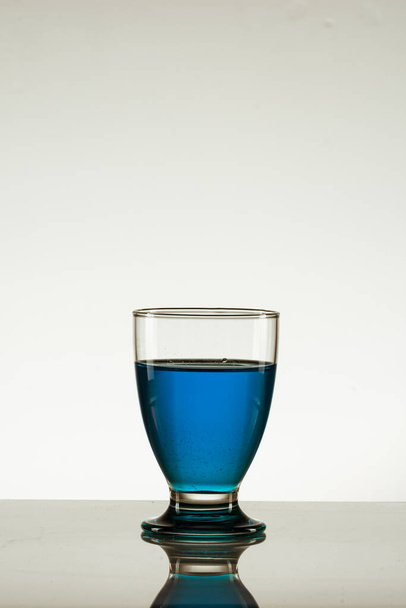 glass of liquid on a white background - Valokuva, kuva