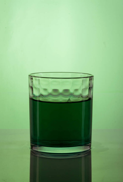 glass of water on a green background - 写真・画像