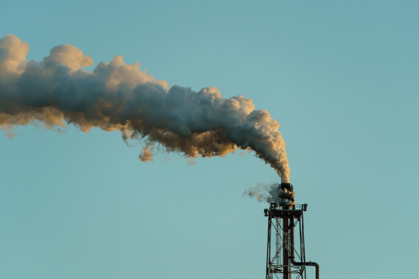 Промышленное предприятие вредит окружающей среде выбросами токсичных газов в атмосферу. - Фото, изображение