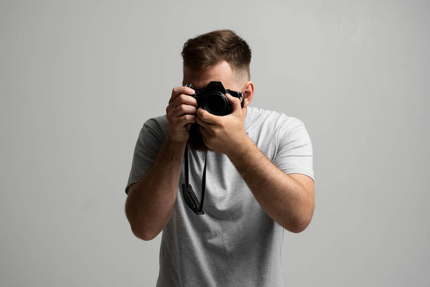 Photography, creative, artist concept. Bearded professional photographer shooting on dslr mirrorless photo camera while working in studio. - Fotografie, Obrázek