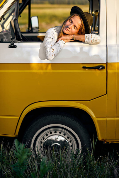 Calm Melancholic Woman Is Leaned On Van Window Having Rest At Summer Evening - Фото, изображение