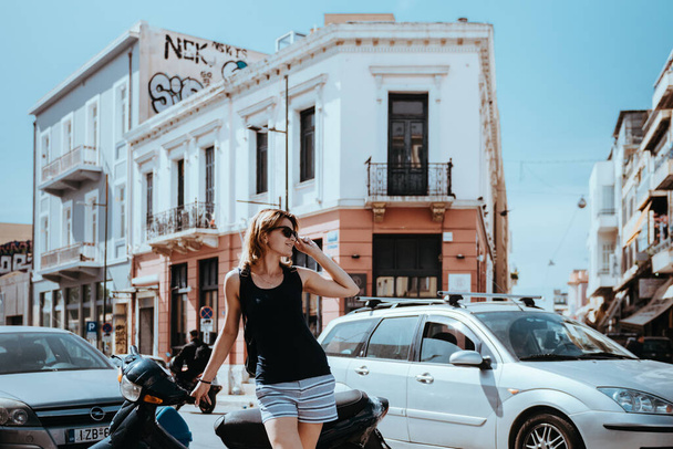 Beautiful girl walking along the street of an old European town, capital of Greece - Athens. Portrait of a tourist girl walking on the street background. - Zdjęcie, obraz