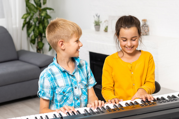 Testvérek szintetizálnak. A gyerekek zongoráznak. családi játékok - Fotó, kép