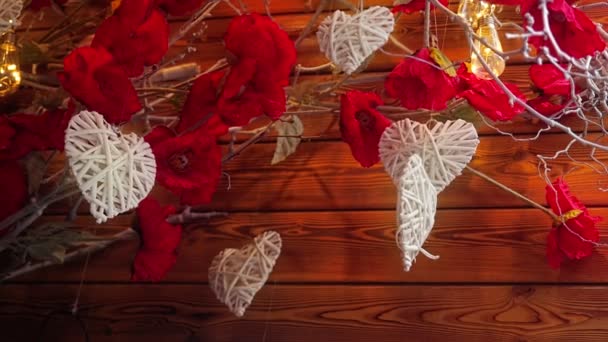 Svatý Valentýn spořič obrazovky. Bílé srdce ve tvaru dekorace visí na houpačce a točit větrem foukal na pozadí svítící světla a suché větve s květinami - Záběry, video