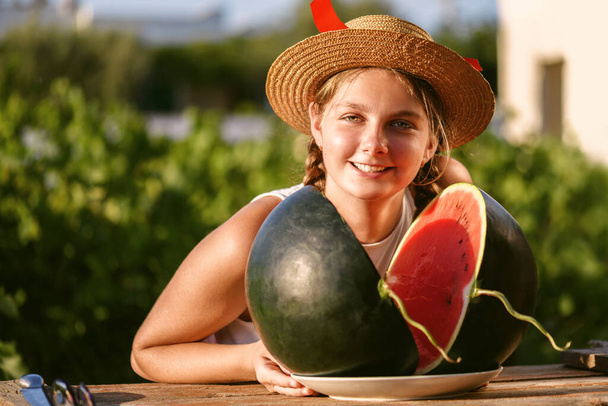 Muotokuva nuori onnellinen tyttö hattu ja iso koko vihreä vesimeloni nauttia ulkona. Teini nauttii kesäelämästä. Kesän elämäntapa käsite. Onnellisuus, ilo, loma Itsenäisyyspäivä - Valokuva, kuva