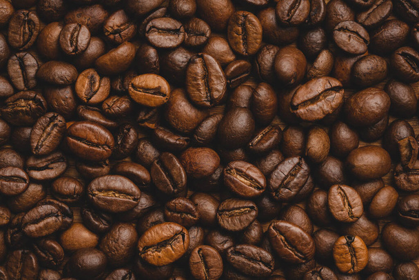 Grains de café torréfiés fond plein Fermer macro brun foncé - Photo, image