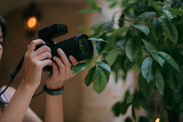 Detailní záběr profesionální kamery v ženských rukou. Fotografka pracuje na natáčení, soustředění, hledání karty, focení - Fotografie, Obrázek