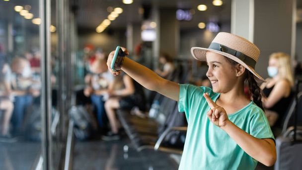 κοριτσάκι με βαλίτσα ταξιδεύει στο αεροδρόμιο, τα παιδιά ταξιδεύουν - Φωτογραφία, εικόνα