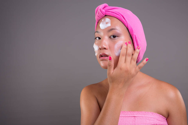 csinos ázsiai nő vigyáz a bőrét elszigetelt a háttérben, szépség koncepció - Fotó, kép
