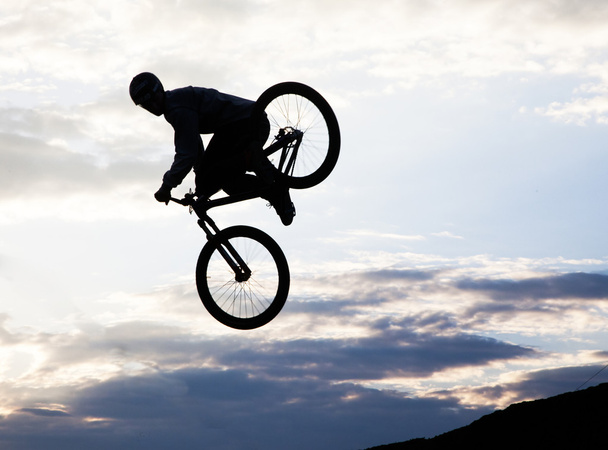 Silhouette d'un homme faisant un saut avec un vélo bmx
  - Photo, image