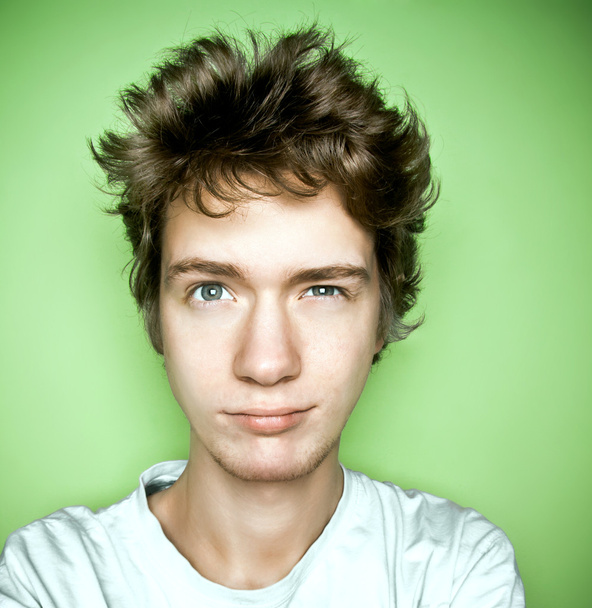 Porträt eines Teenagers, der nach oben schaut, auf grünem Hintergrund. - Foto, Bild