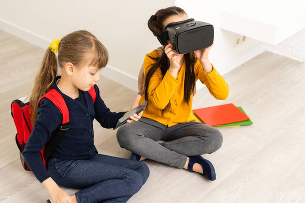 Two girls in headset virtual vr reality. Childhood kids education lifestyle concept - Photo, Image