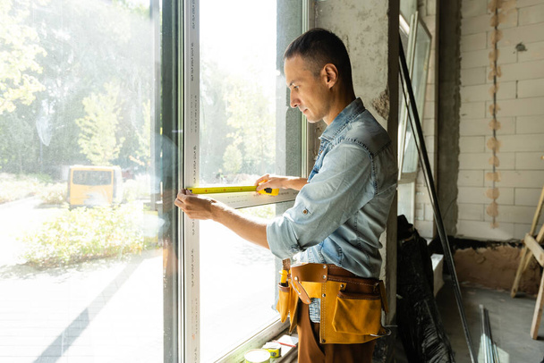 stavební dělník instaluje okno v domě - Fotografie, Obrázek