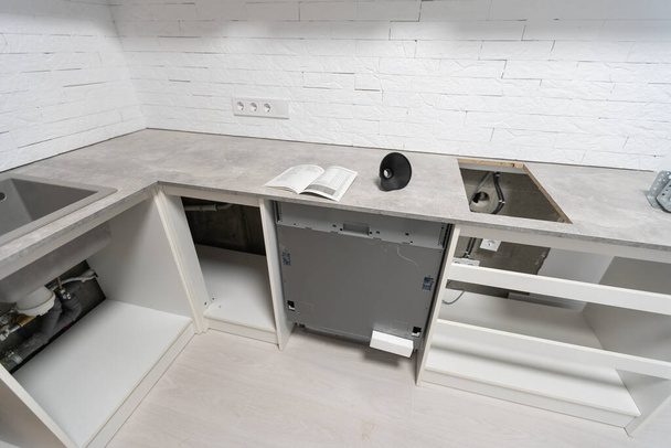 Cocina moderna con lavavajillas empotrado vacío, fregadero de cocina de acero inoxidable. Cocina de tono blanco. - Foto, imagen